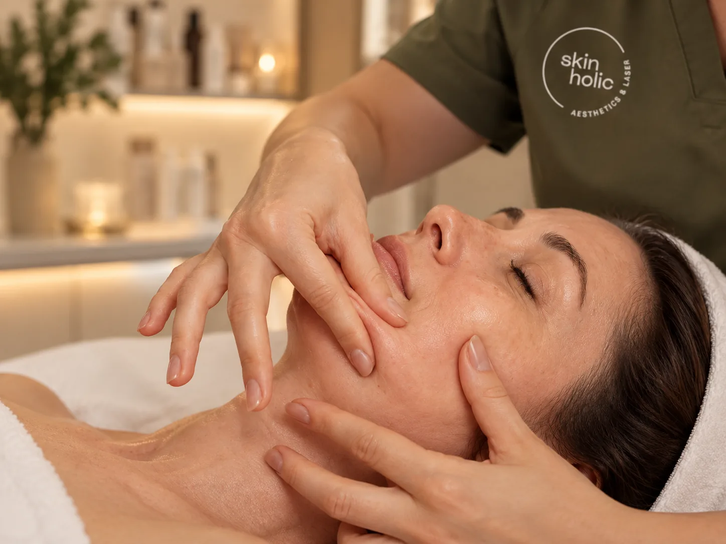 Practitioner's hands massage around a woman's mouth, cheek and jaw during buccal therapy
